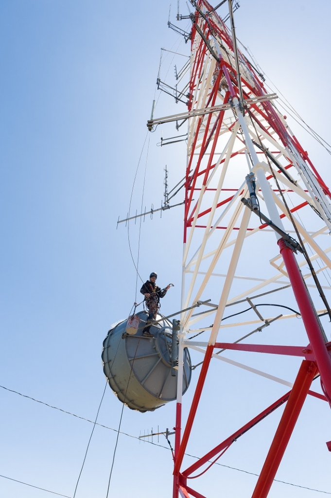 Man Working on Radio Tower man working using rope access on tall tower